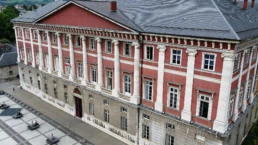 Bâtiment historique à Chambéry avec architecture élégante et vue sur les montagnes.